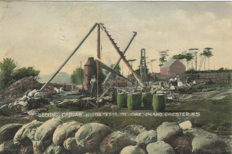 Tinted postcard of a 19th-century dig: timber hoists and a boiler over the shaft, with workers and barrels among shoreline boulders.